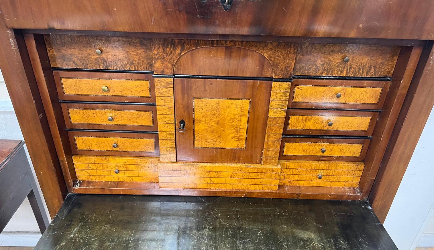 An early 19th century Berlin Biedermeier mahogany and parcel ebonised secretaire, in the manner of Schinkel, width 106cm, depth 54cm, height 195cm